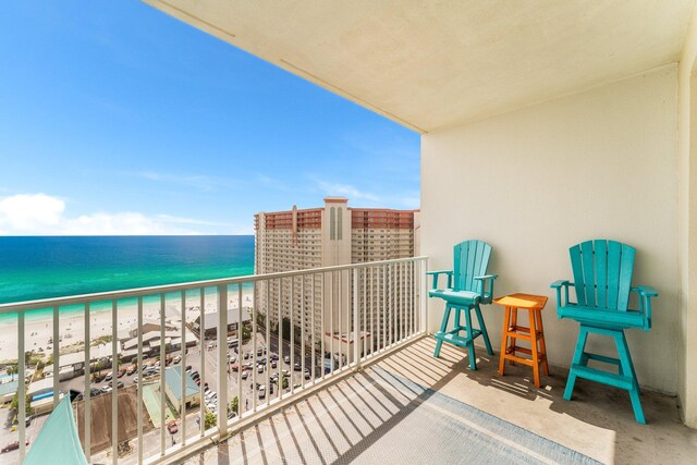 balcony featuring a water view and a beach view