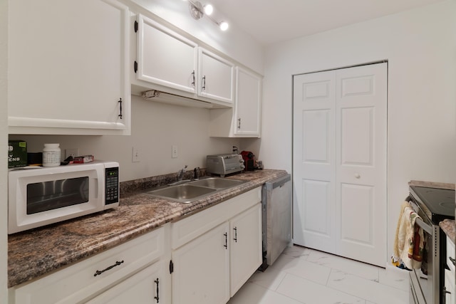 kitchen featuring dark stone counters, sink, stainless steel appliances, and white cabinets