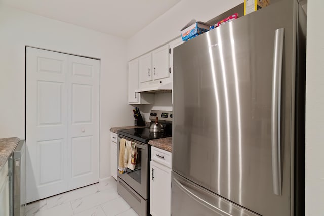 kitchen featuring dark stone counters, white cabinetry, and stainless steel appliances