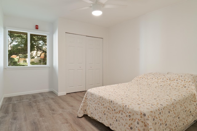 bedroom featuring ceiling fan, light wood-type flooring, and a closet