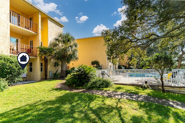 view of yard with a balcony and a fenced in pool