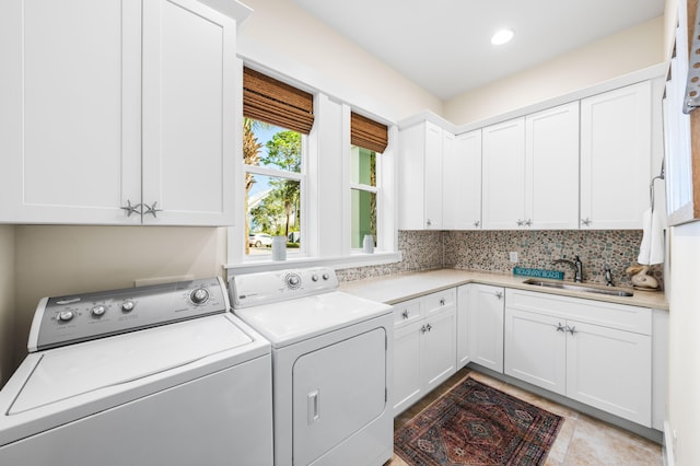 laundry room featuring sink, washer and dryer, and cabinets