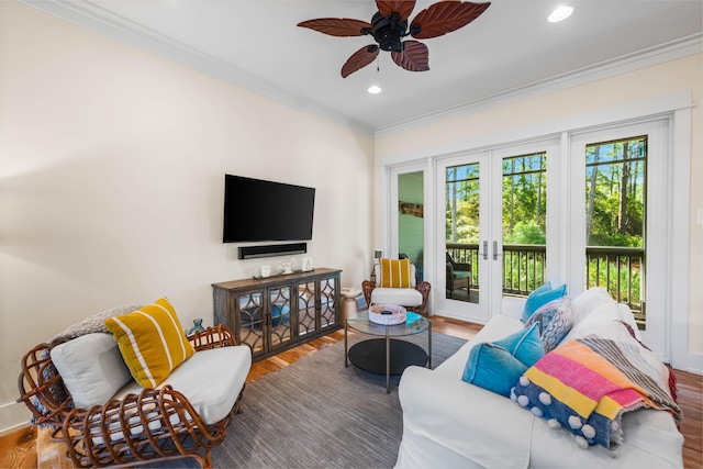 living room featuring wood-type flooring, ornamental molding, ceiling fan, and french doors