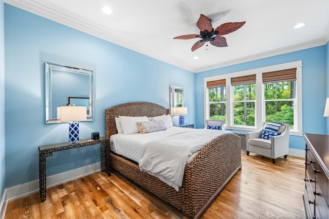 bedroom with ceiling fan, crown molding, and light hardwood / wood-style floors