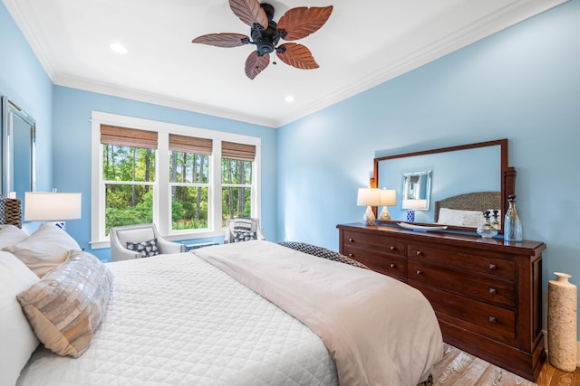 bedroom with ceiling fan, ornamental molding, and light hardwood / wood-style floors