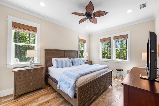 bedroom featuring ceiling fan, light wood-type flooring, and ornamental molding