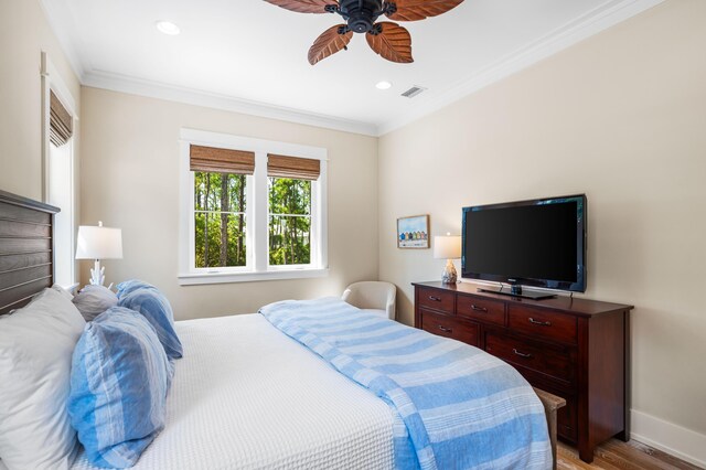 bedroom featuring light wood-type flooring, crown molding, and ceiling fan