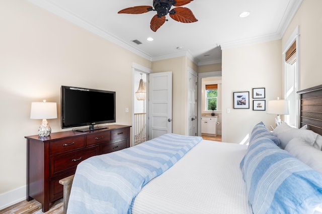 bedroom featuring light wood-type flooring, ensuite bath, ceiling fan, and crown molding