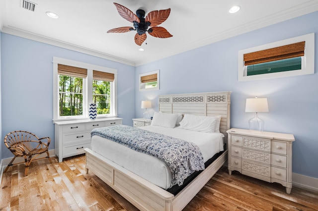 bedroom with light wood-type flooring, ornamental molding, and ceiling fan