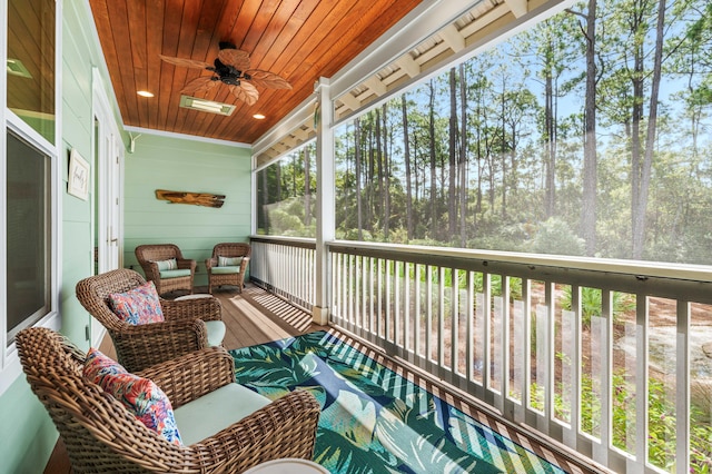 sunroom with ceiling fan, a wealth of natural light, and wooden ceiling