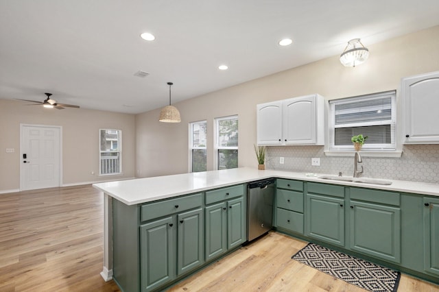 kitchen featuring kitchen peninsula, decorative light fixtures, white cabinetry, dishwasher, and light hardwood / wood-style floors