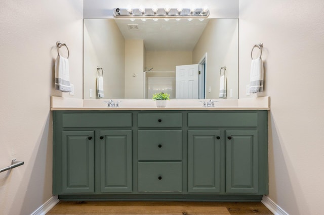 bathroom featuring hardwood / wood-style floors, walk in shower, and vanity