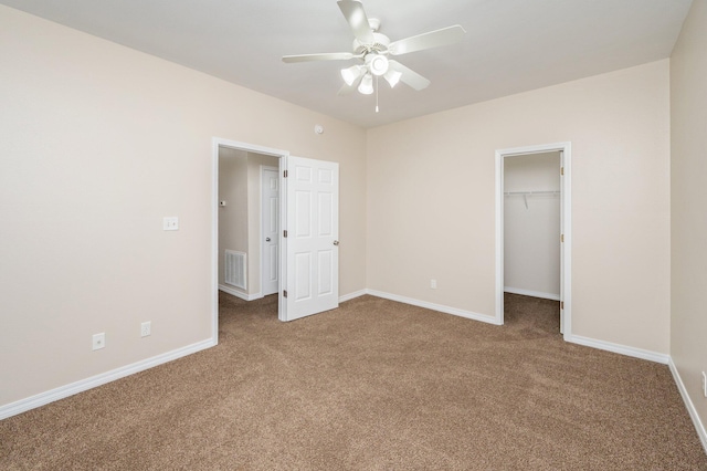 unfurnished bedroom featuring ceiling fan, carpet floors, a closet, and a spacious closet