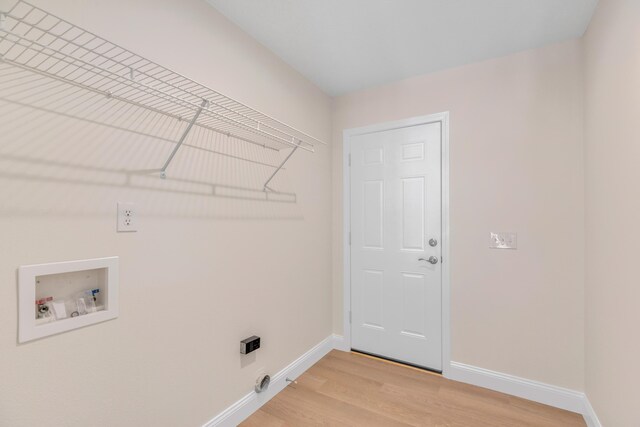 clothes washing area with washer hookup, light wood-type flooring, electric dryer hookup, and hookup for a gas dryer