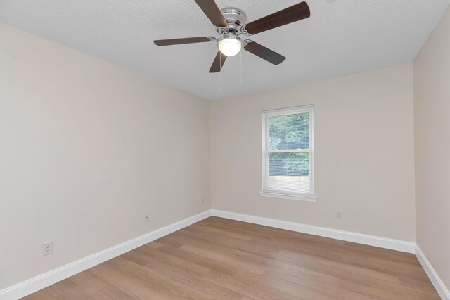 empty room featuring a textured ceiling, light hardwood / wood-style flooring, and ceiling fan