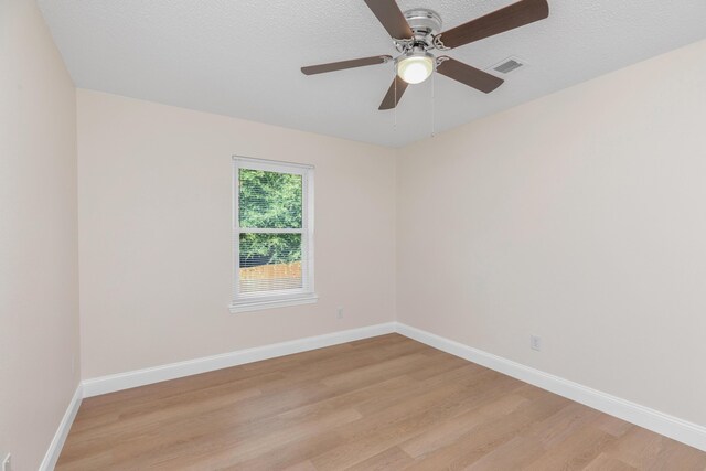 empty room with a textured ceiling, light hardwood / wood-style flooring, and ceiling fan