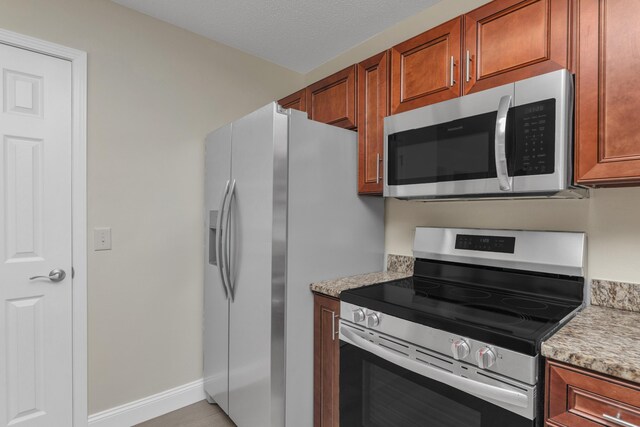 kitchen with appliances with stainless steel finishes and light stone counters