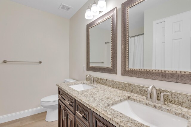 bathroom featuring toilet, hardwood / wood-style flooring, and vanity