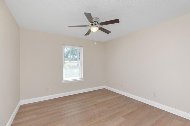 empty room with ceiling fan, a textured ceiling, and light hardwood / wood-style flooring