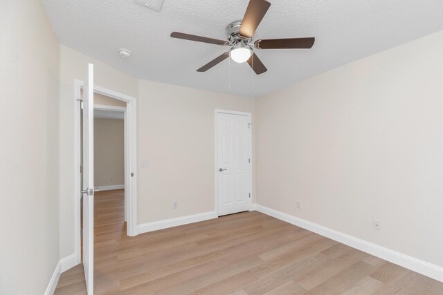 unfurnished bedroom with a textured ceiling, light hardwood / wood-style flooring, and ceiling fan