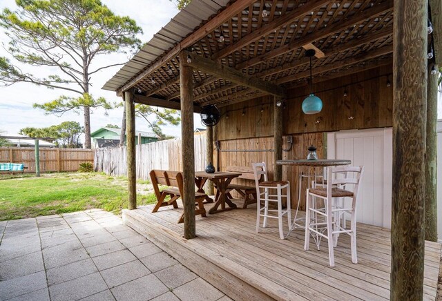 wooden terrace with a lawn and a patio