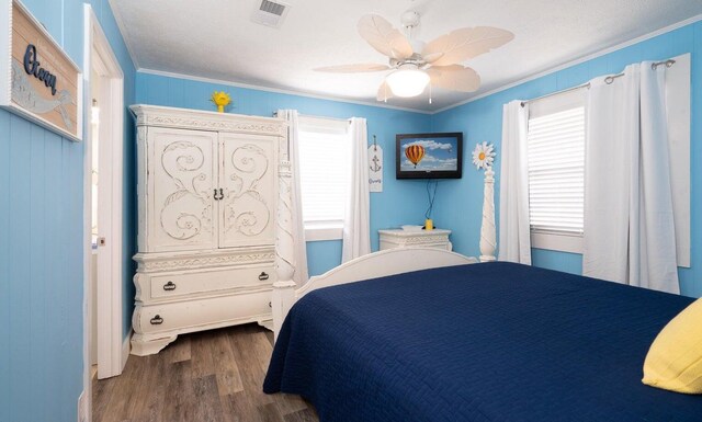 bedroom with ceiling fan, dark hardwood / wood-style flooring, and ornamental molding