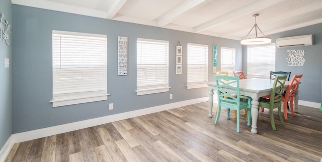 dining room with a wall unit AC, hardwood / wood-style flooring, and beamed ceiling