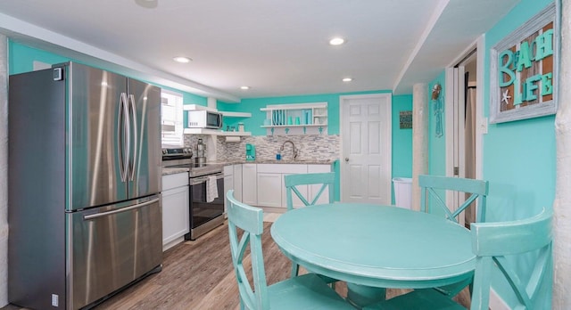 dining space with light hardwood / wood-style flooring and sink