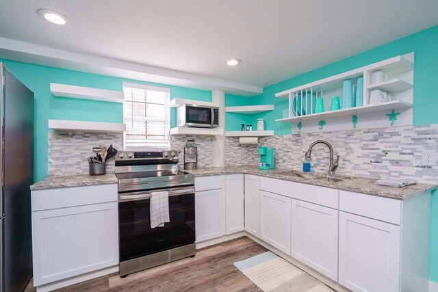 kitchen featuring light hardwood / wood-style flooring, white cabinets, stainless steel appliances, and sink