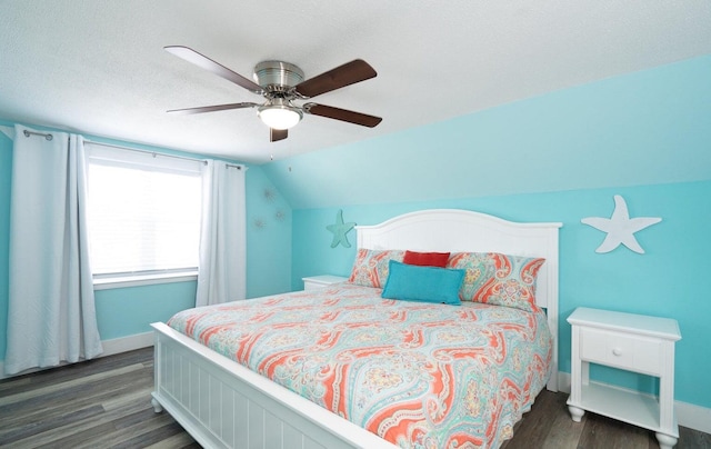 bedroom with a textured ceiling, dark wood-type flooring, ceiling fan, and vaulted ceiling