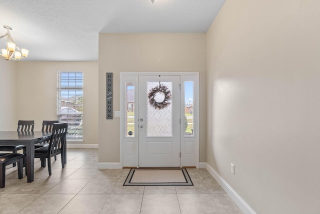 tiled entryway with a notable chandelier