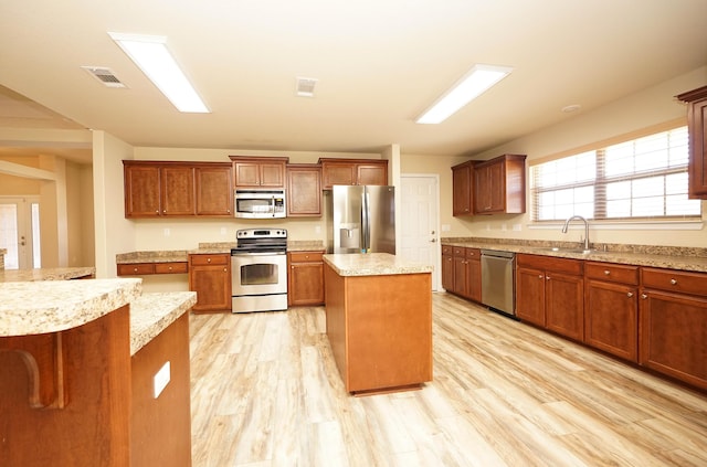 kitchen featuring a center island, stainless steel appliances, light hardwood / wood-style flooring, and sink