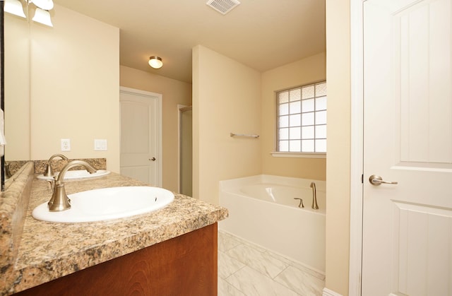 bathroom featuring a washtub and vanity