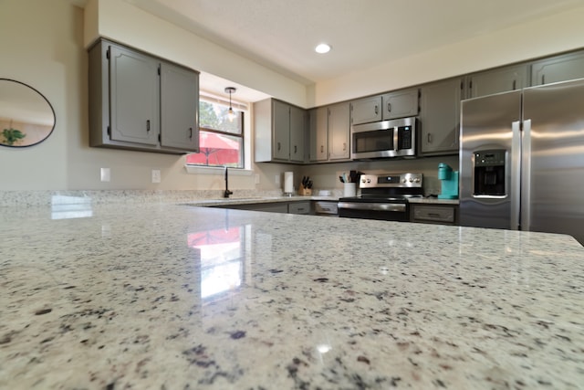 kitchen with gray cabinets, light stone countertops, sink, and appliances with stainless steel finishes