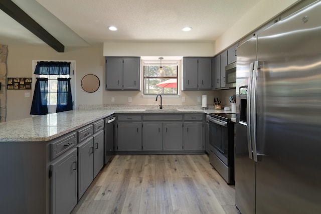 kitchen with kitchen peninsula, stainless steel appliances, gray cabinetry, and sink