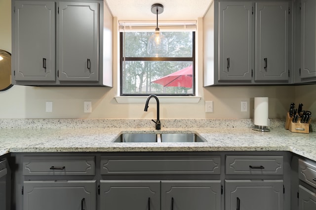 kitchen featuring gray cabinetry, sink, and a textured ceiling