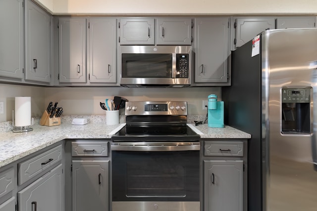 kitchen with gray cabinetry and appliances with stainless steel finishes