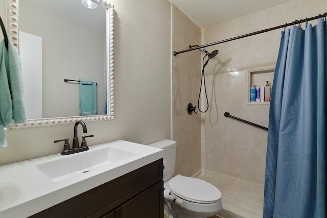 bathroom featuring curtained shower, vanity, a textured ceiling, and toilet