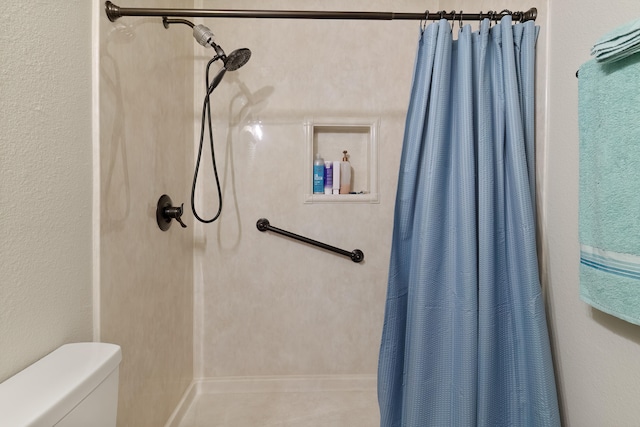 bathroom featuring a shower with shower curtain and toilet