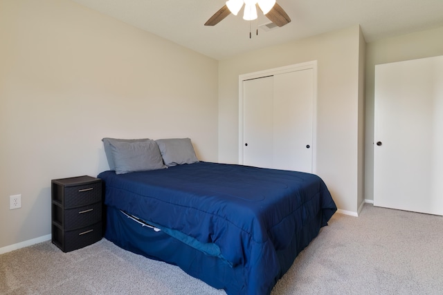 bedroom featuring ceiling fan, light colored carpet, and a closet