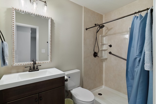 bathroom with toilet, vanity, a textured ceiling, and walk in shower