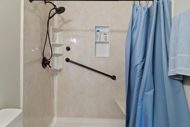 bathroom featuring a shower with curtain and toilet