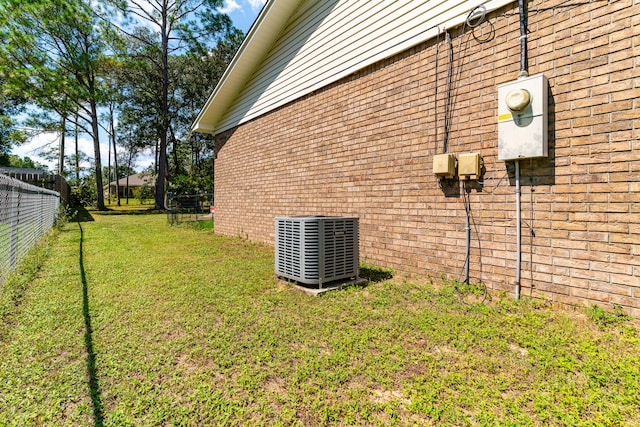 view of side of home with a yard and central air condition unit