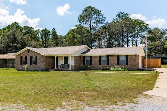 single story home featuring covered porch and a front yard