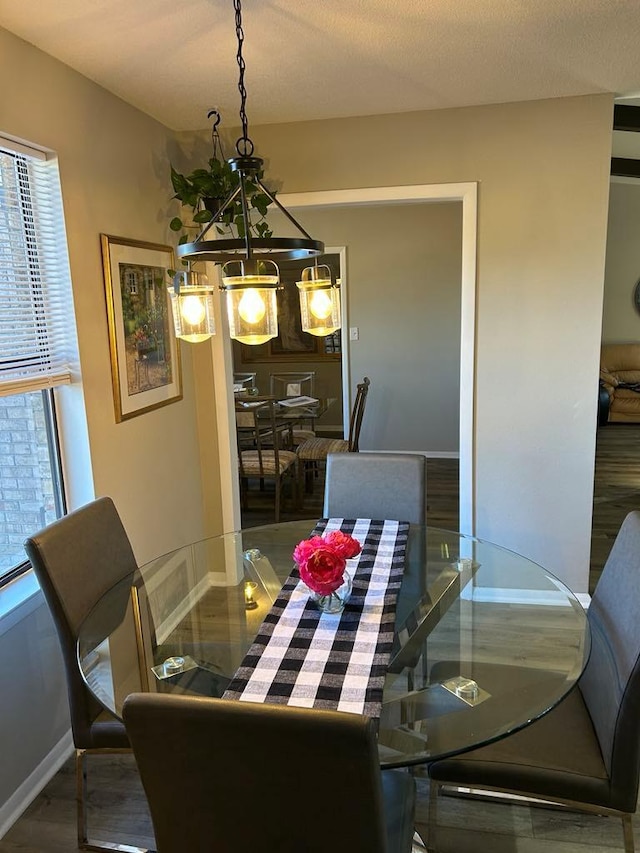 dining room featuring dark hardwood / wood-style flooring and a textured ceiling