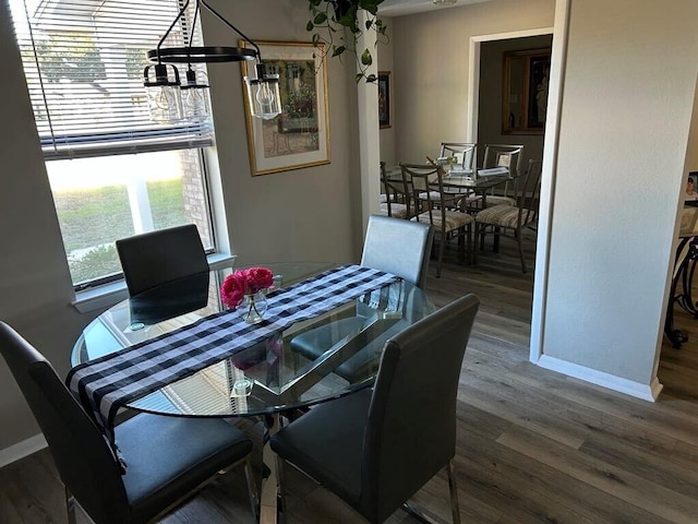 dining space featuring wood-type flooring and a chandelier