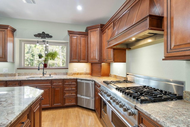 kitchen with custom range hood, light hardwood / wood-style floors, light stone countertops, stainless steel stovetop, and sink