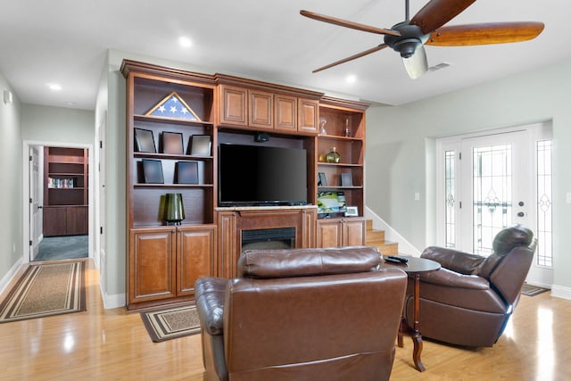 living room featuring light wood-type flooring and ceiling fan