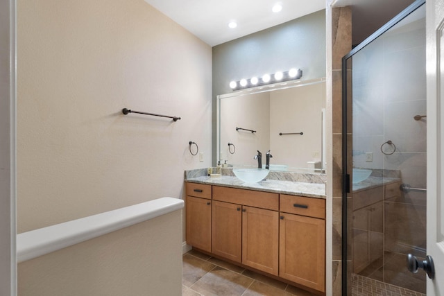 bathroom with tile patterned flooring, a shower with shower door, and vanity