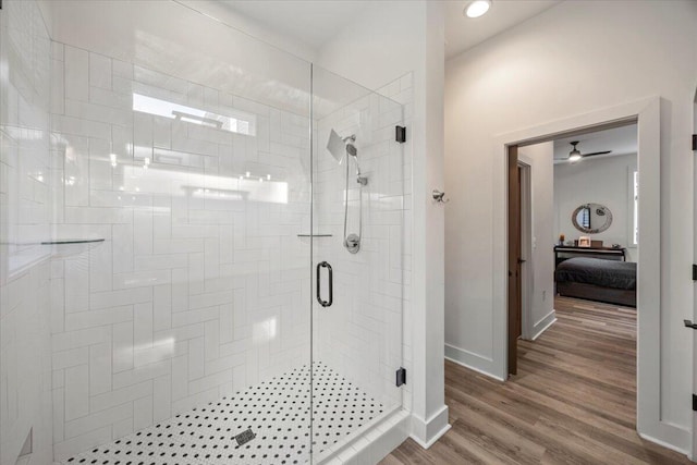 bathroom featuring hardwood / wood-style flooring, ceiling fan, and a shower with door